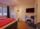 Upland Apartments/Fewo Zeitgeist - Schlafzimmer-1 mit TV und Kommode